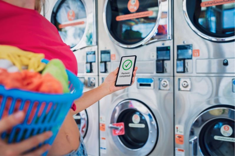Pagando con el celular en una lavandería automática